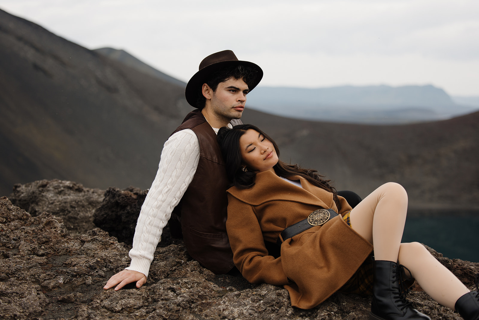 bride lays on groom while looking at the scenery of iceland around them