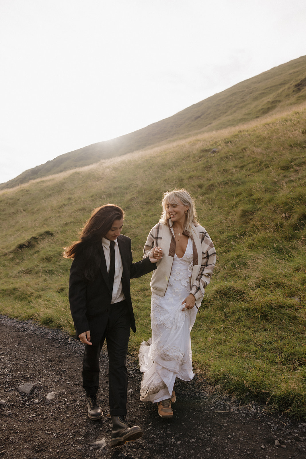 same sex couple candidly walk while holding hands in iceland