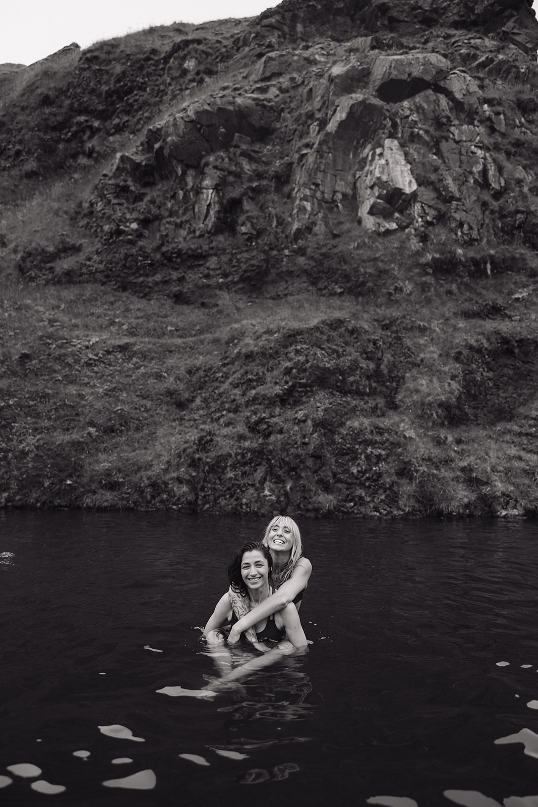 same sex couple show affection with each other in a hot springs in iceland