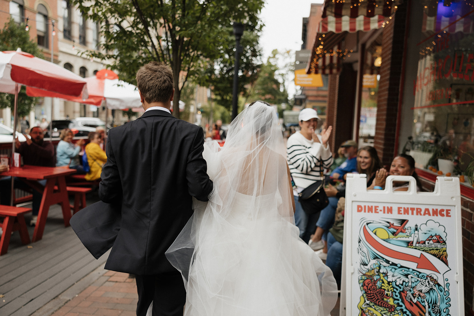 Bride and groom getting cheers from strangers in downtown Portland, Maine