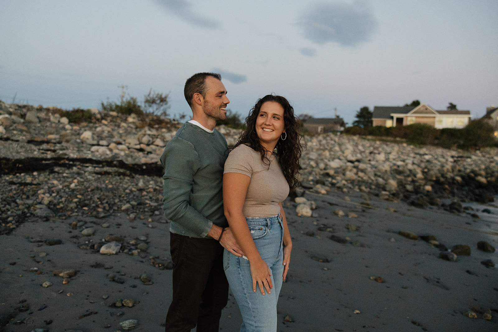 stunning couple pose for a photo on the beach during their East Coast beach engagement photoshoot