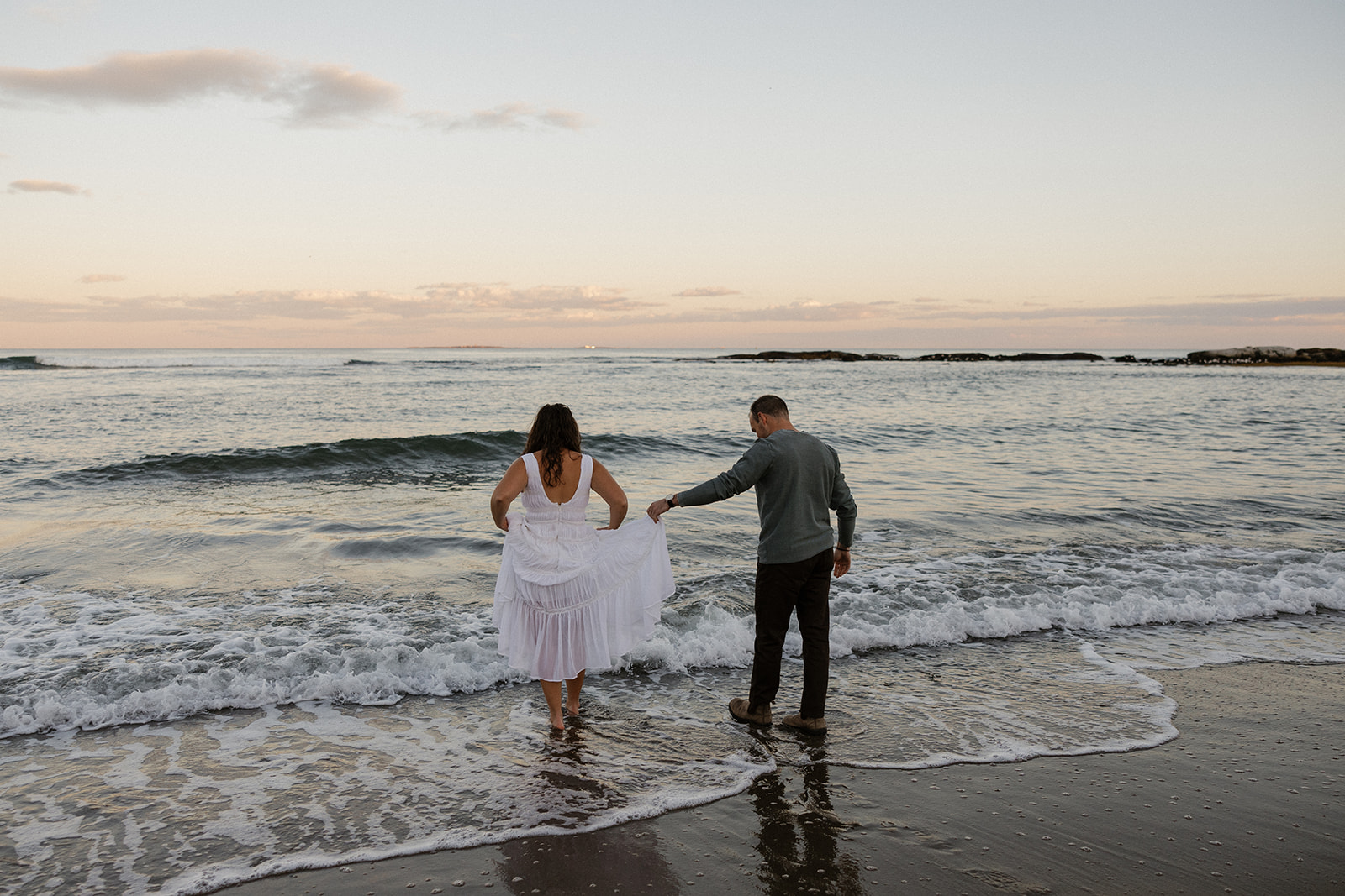stunning couple pose for a photo on the beach during their East Coast beach engagement photoshoot