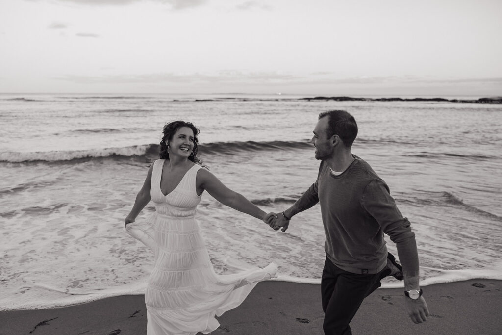 stunning couple pose for a photo on the beach during their East Coast beach engagement photoshoot