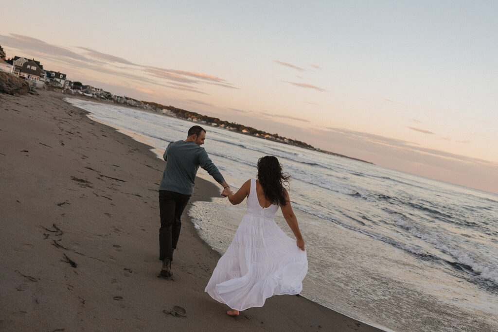 stunning couple pose for a photo on the beach during their East Coast beach engagement photoshoot