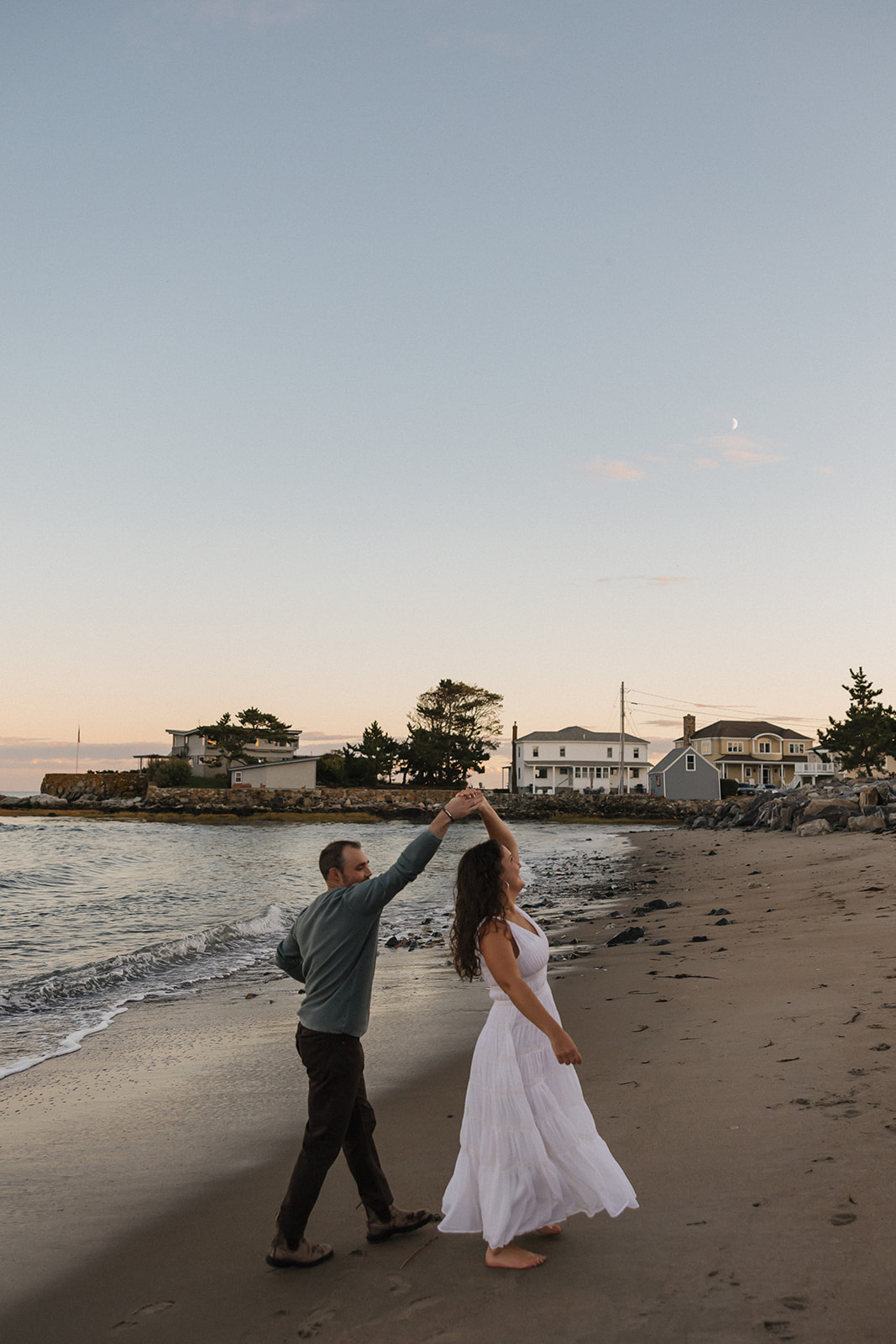 stunning couple pose for a photo on the beach during their East Coast beach engagement photoshoot