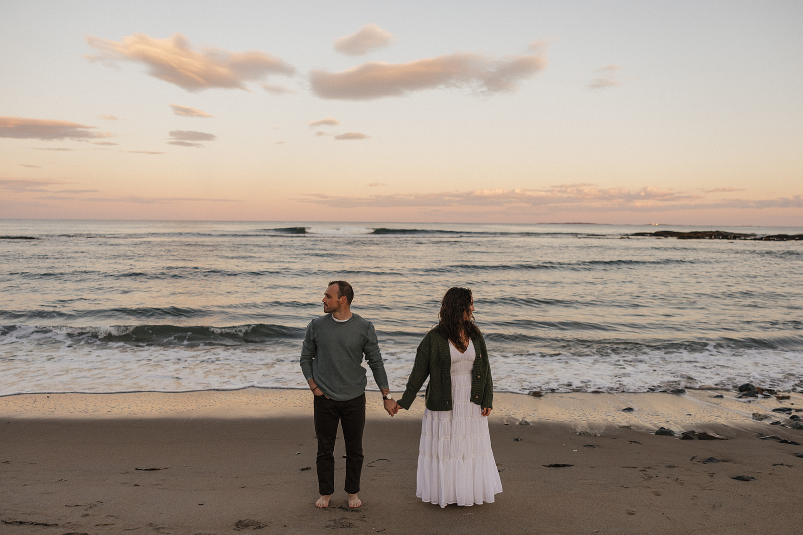 stunning couple pose for a photo on the beach during their East Coast beach engagement photoshoot