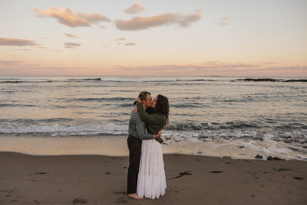 stunning couple pose for a photo on the beach during their East Coast beach engagement photoshoot