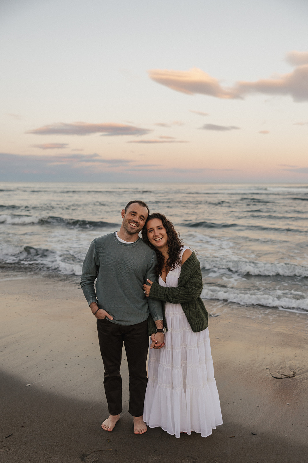 stunning couple pose for a photo on the beach during their East Coast beach engagement photoshoot