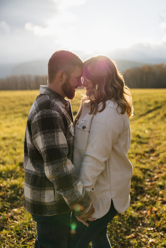 Natural and playful couple portraits in a field near Cathedral Ledge and Echo Lake in New Hampshire