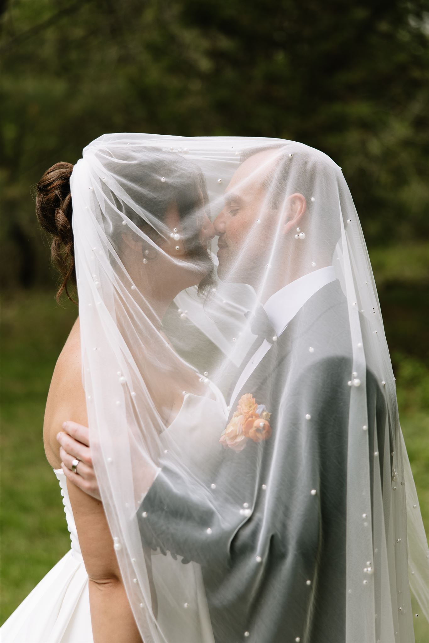 Bride at Groom pose under veil at Sunday Supper in Kittery Maine