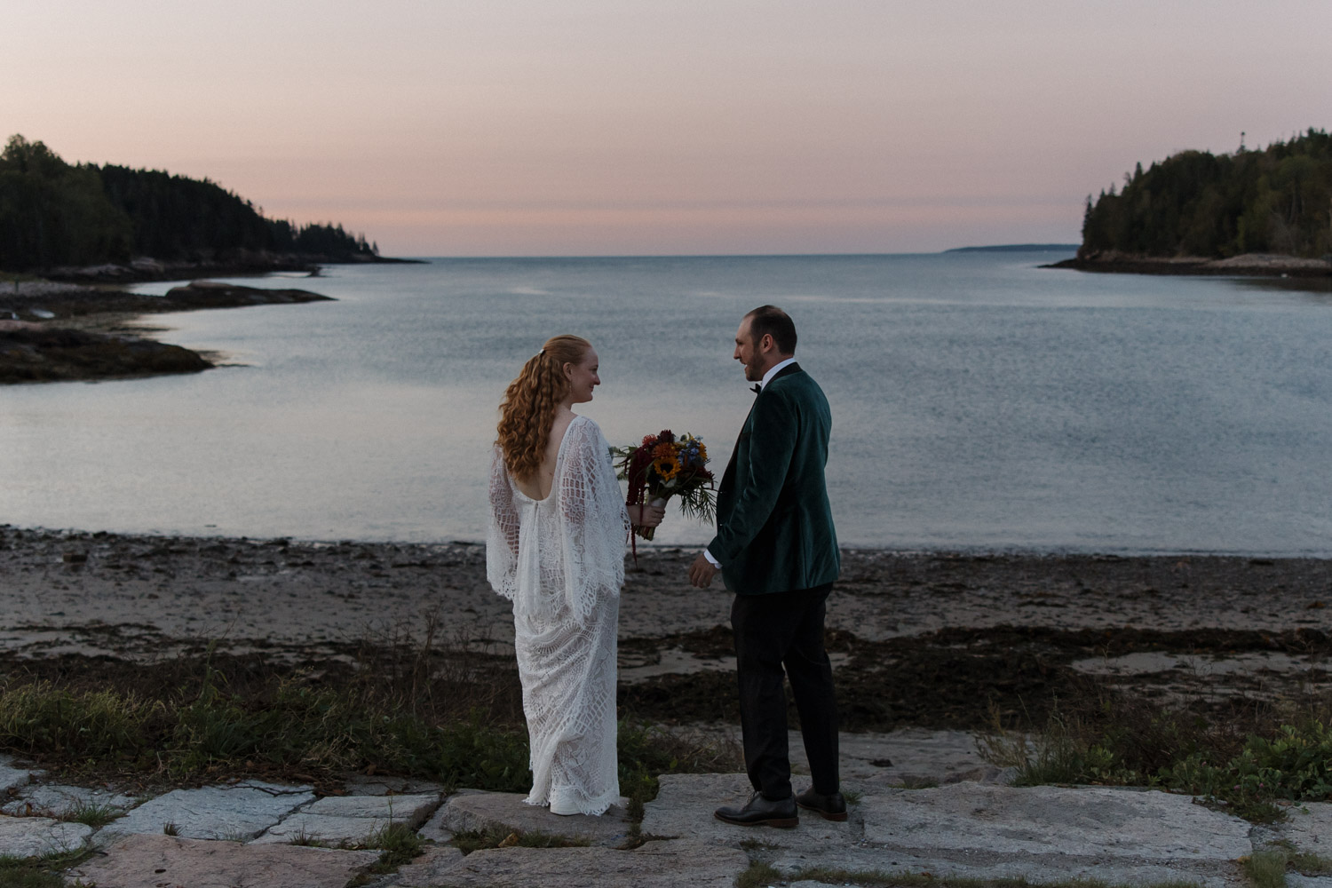 bride and groom stand bayside during their golden hour elopement