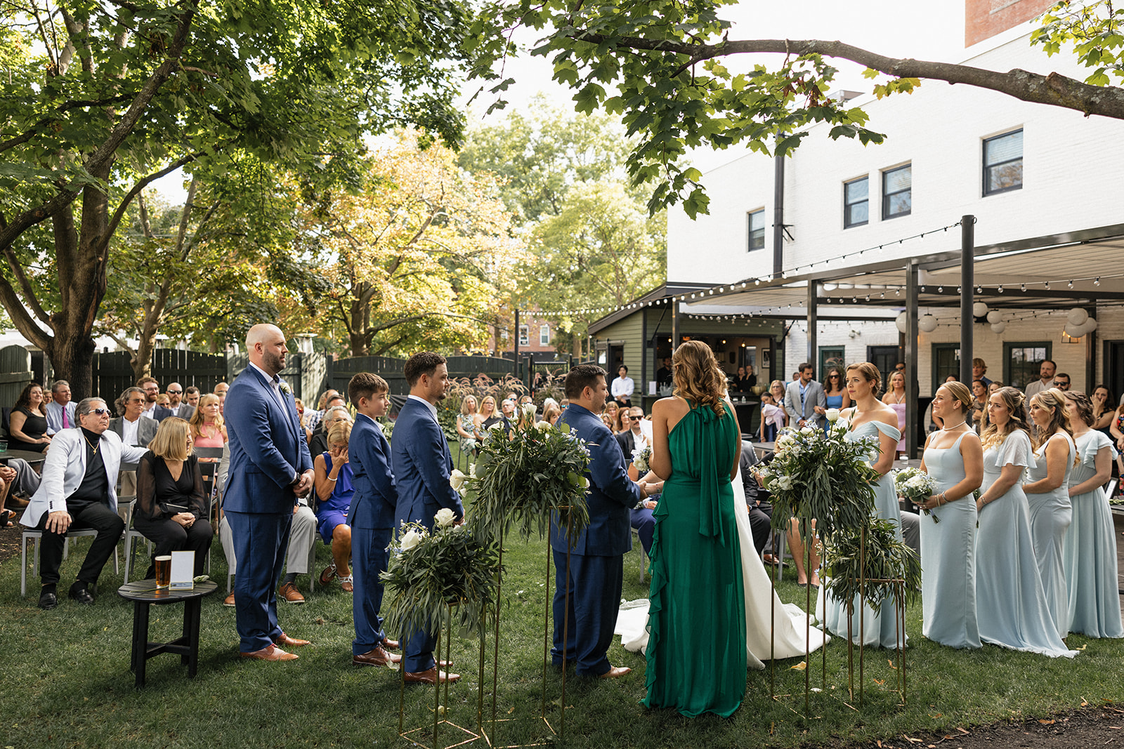wedding ceremony takes place in a serene backyard