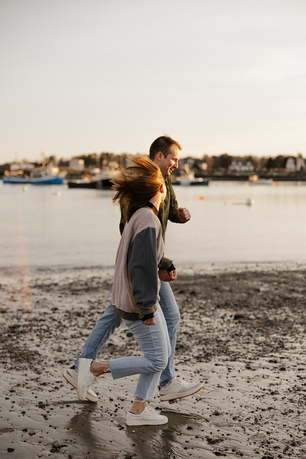 stunning couple run on the beach together during their Portsmouth NH photoshoot