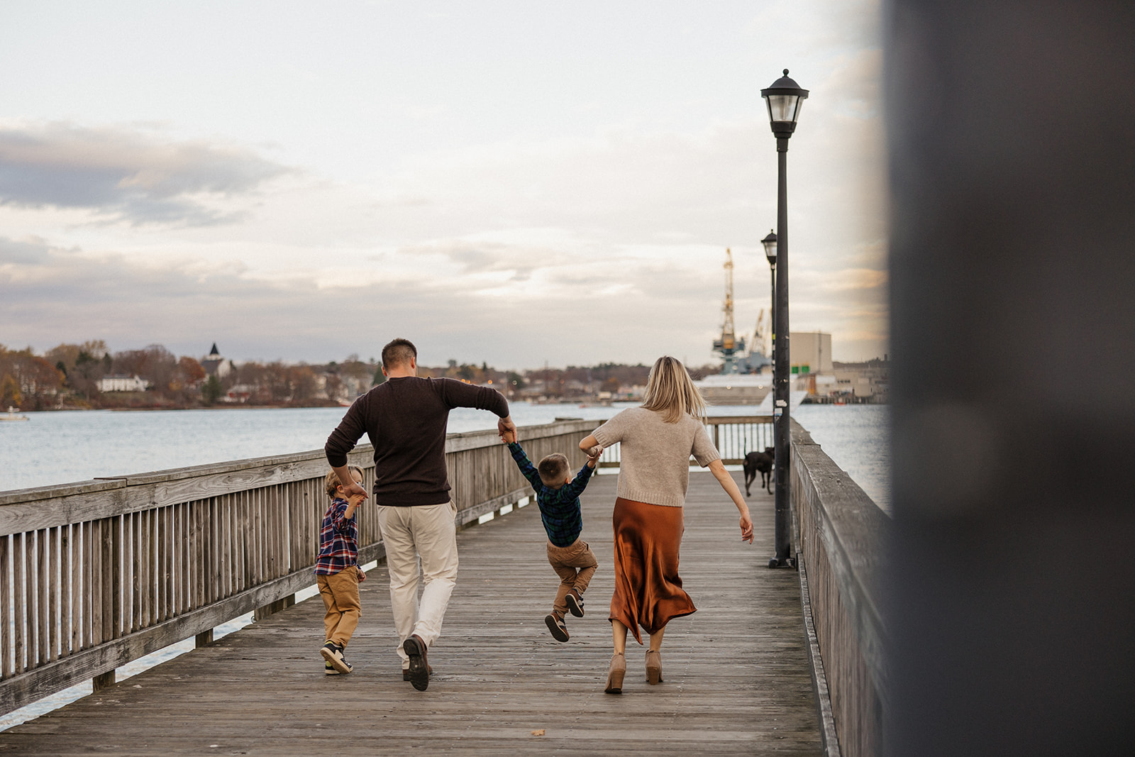 adorable family run along the dock during their family photoshoot