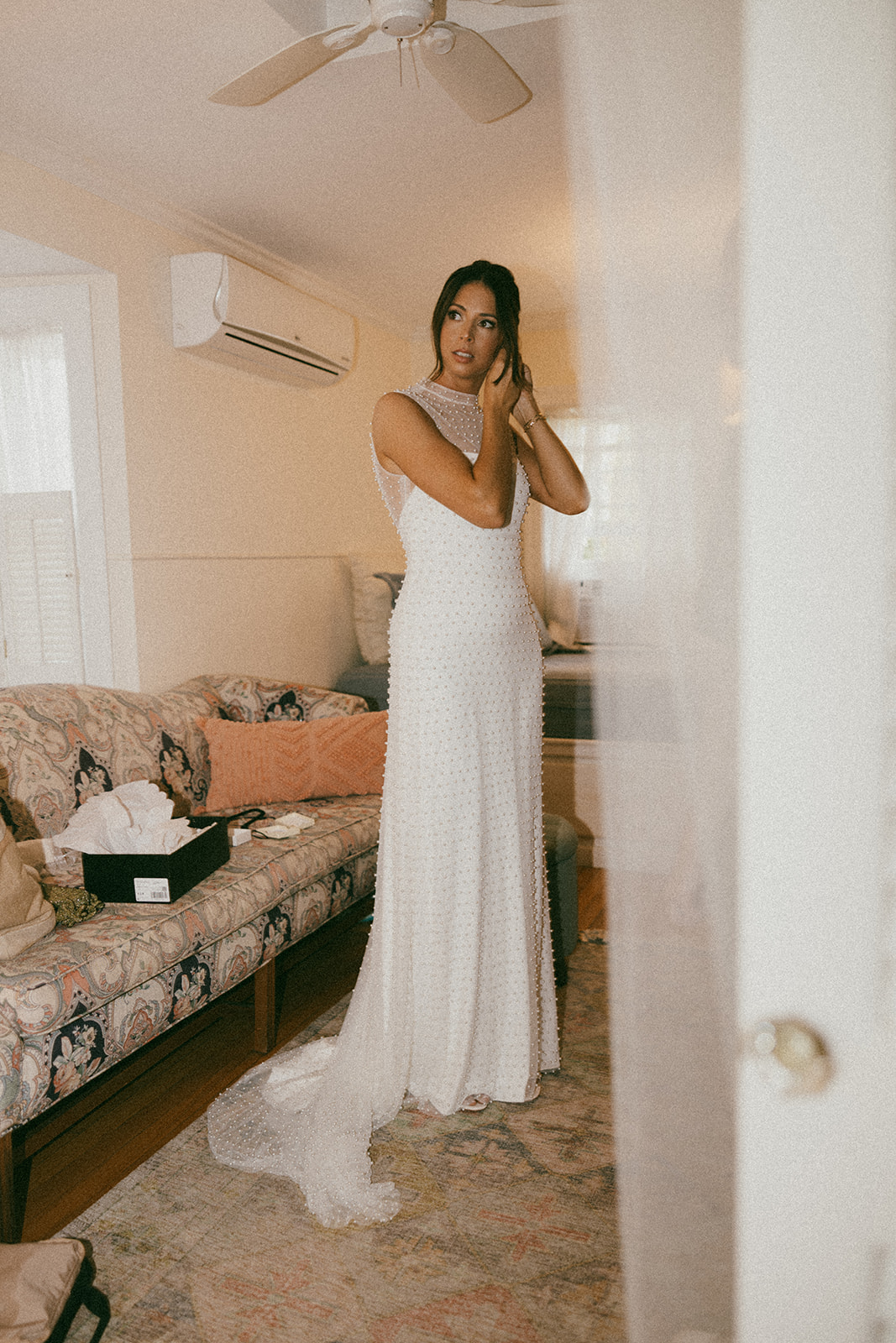bride puts her earrings in during her getting ready photos