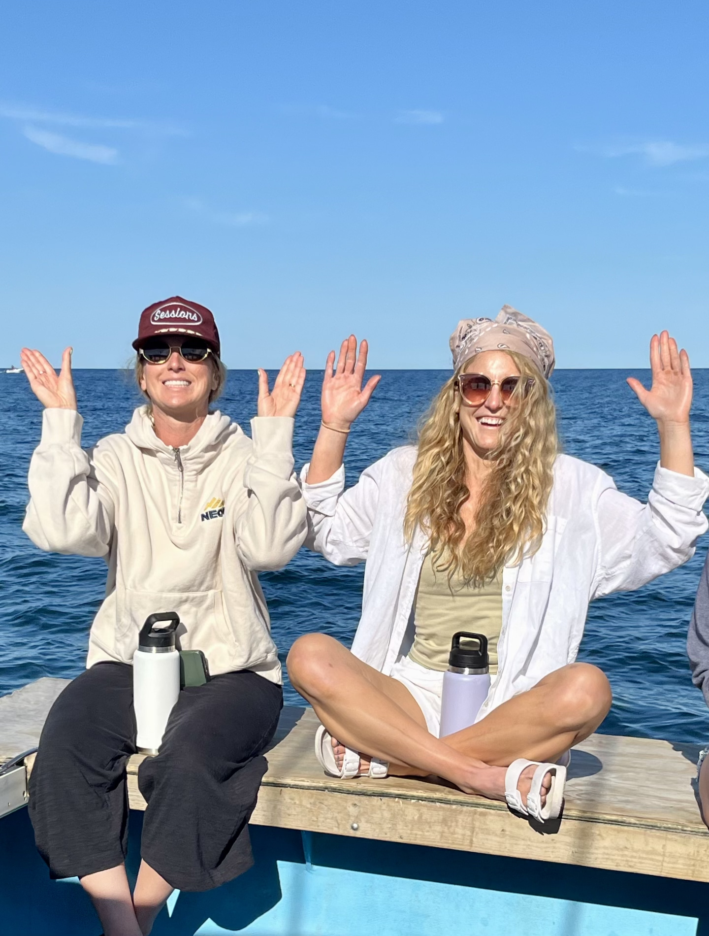 Erica and her sister pose or a photo on the edge of a boat