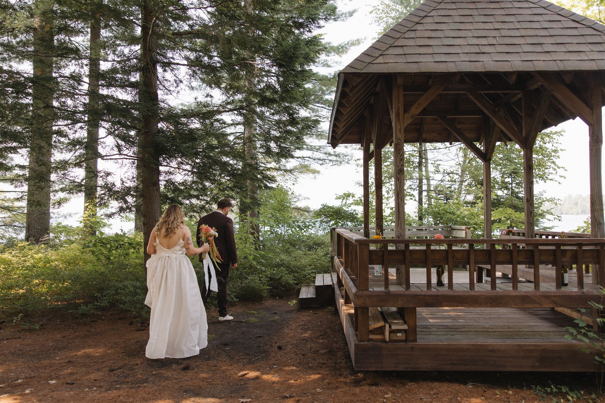 documentary photo of a bride and groom walking to the gazebo at Sebago lake!