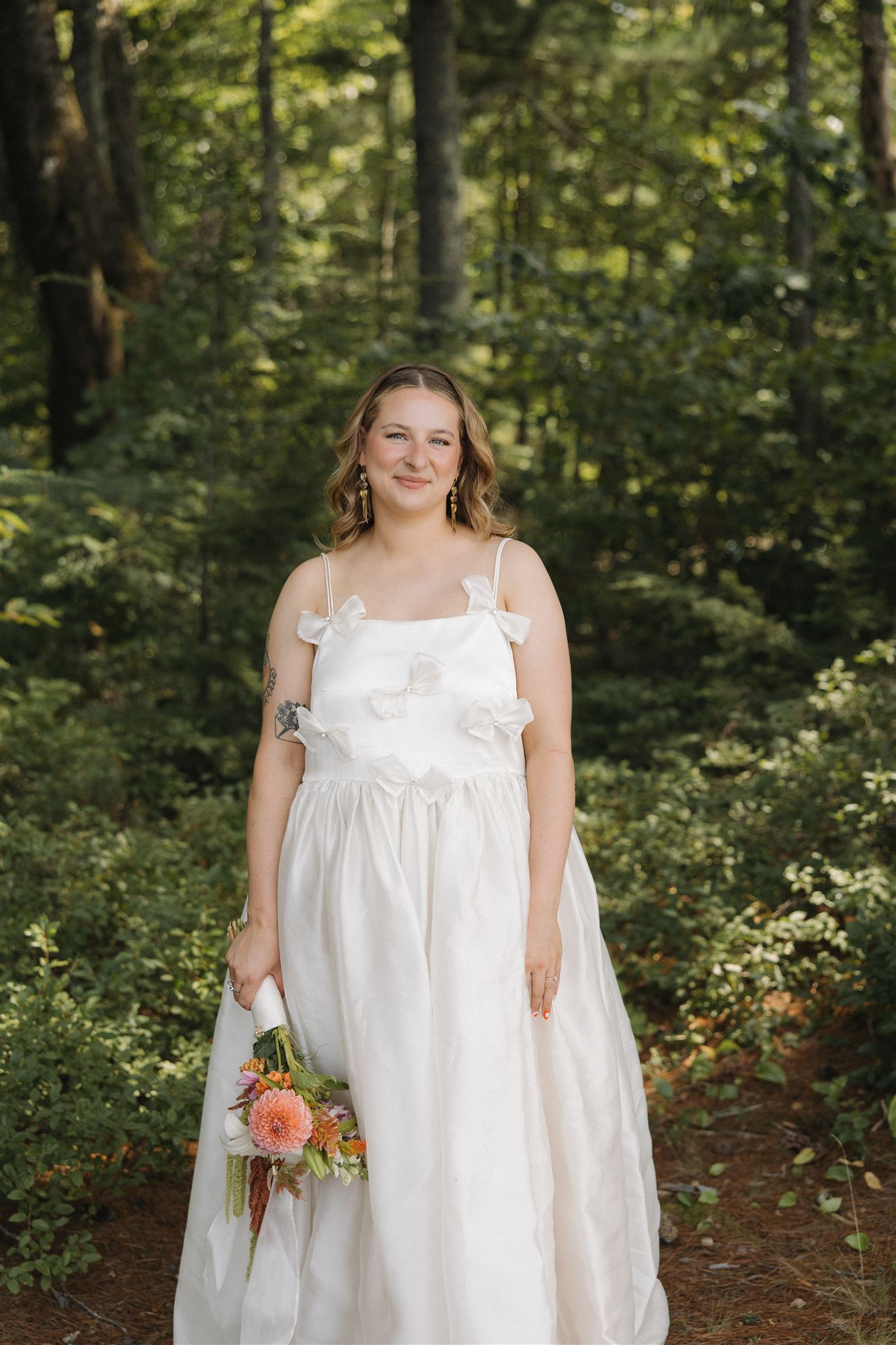 bride poses for a photo in the forrest