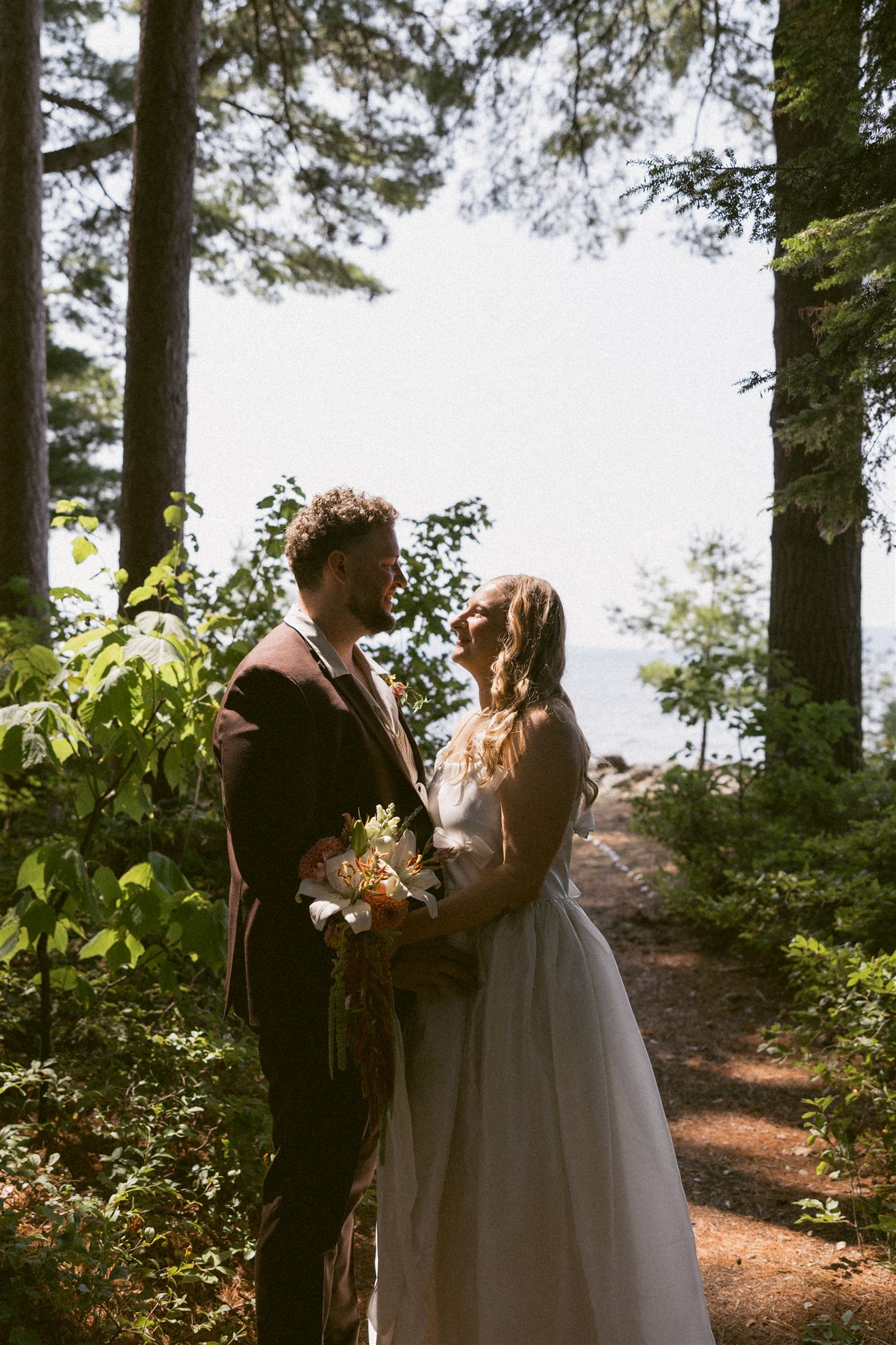 bride and groom pose in the forrest together
