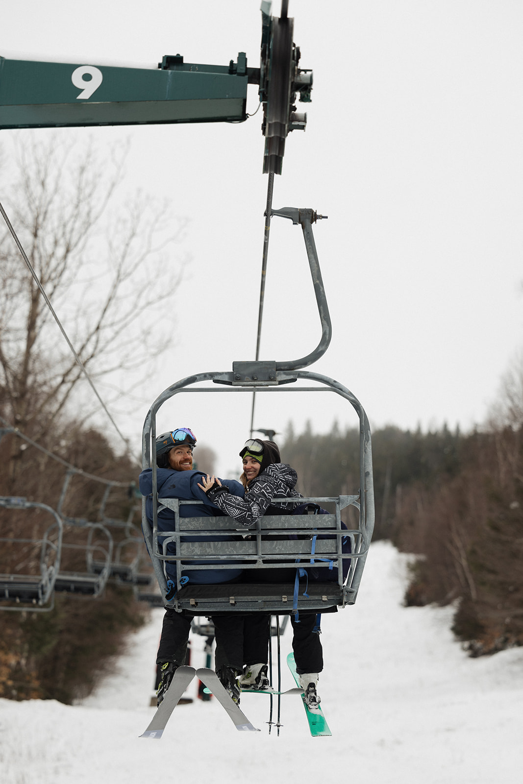 couple turn around and smile at Erica Warren photography on the ski lift