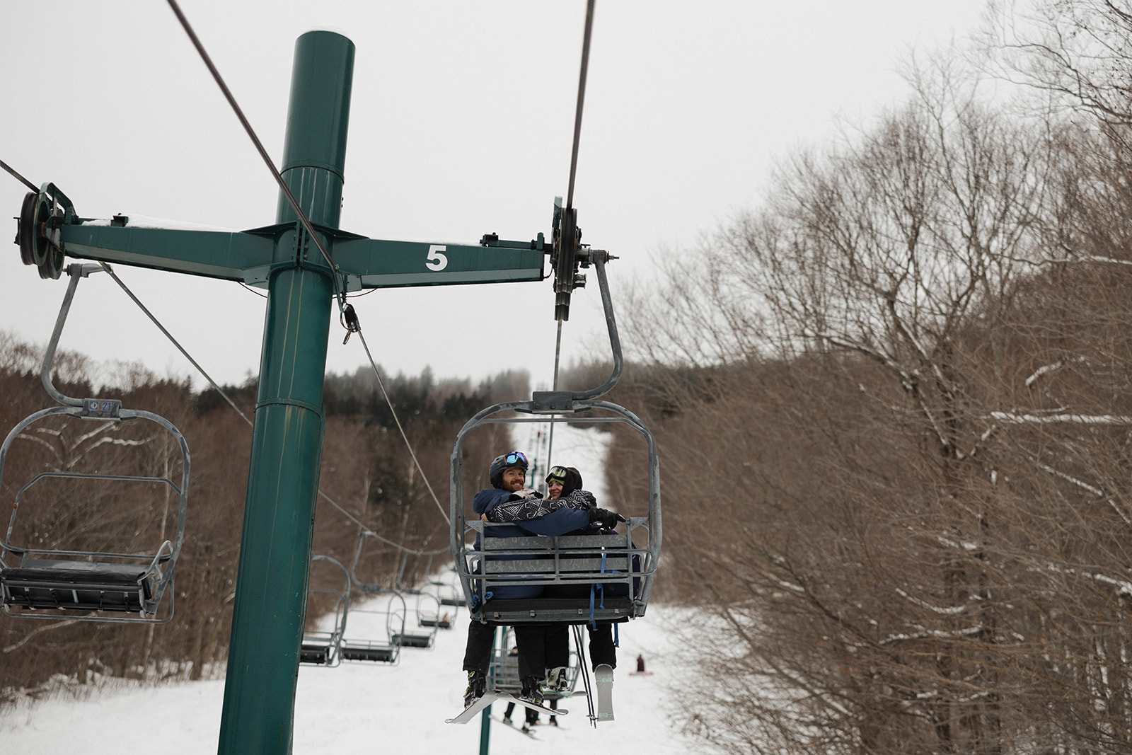couple turn around and smile at Erica Warren photography on the ski lift