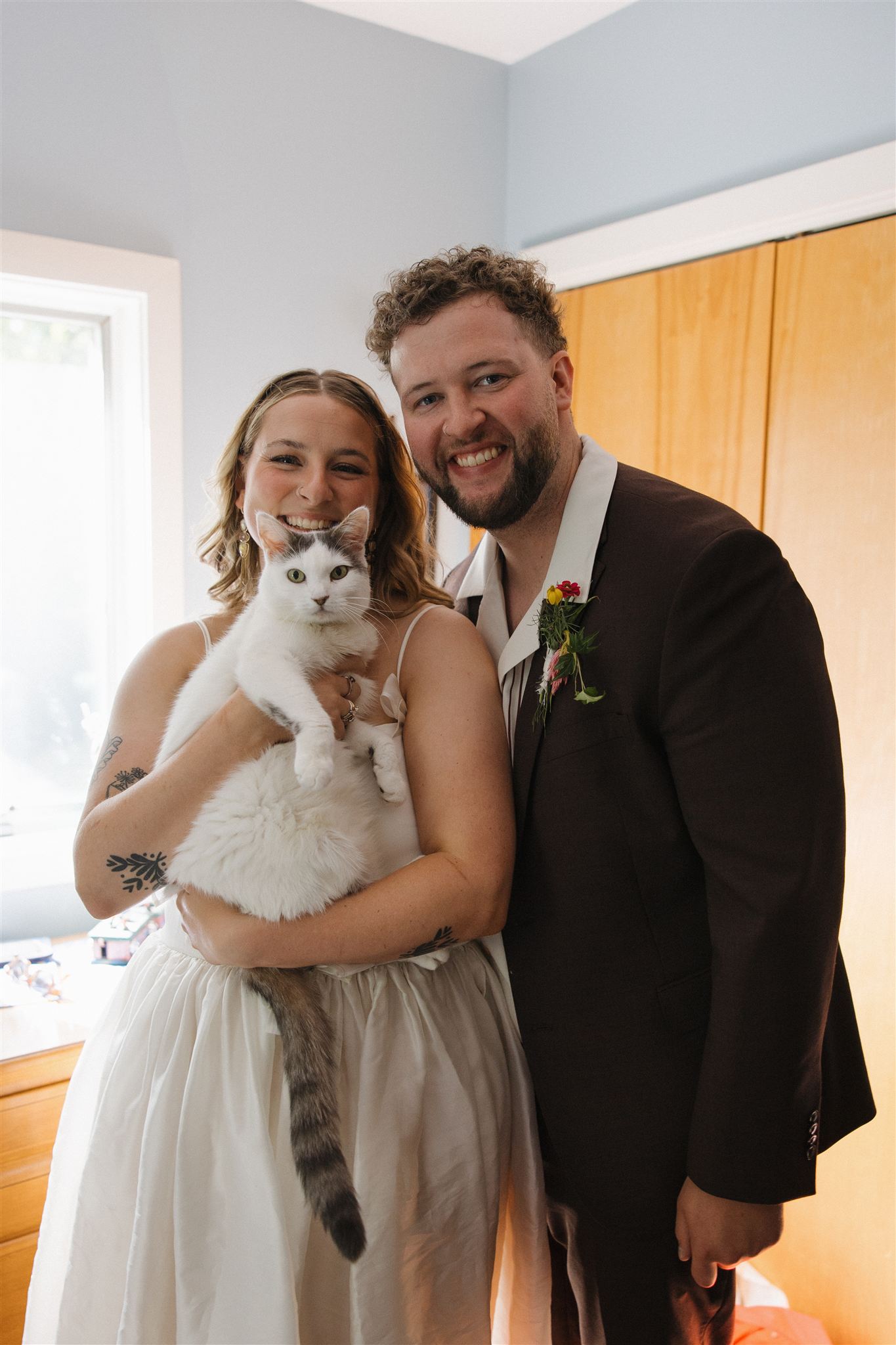 bride and groom pose with their beautiful white and grey kitty kat