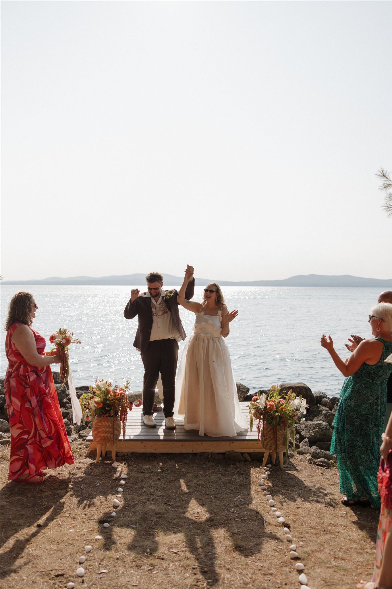 bride and groom celebrate at their lakeside ceremony site