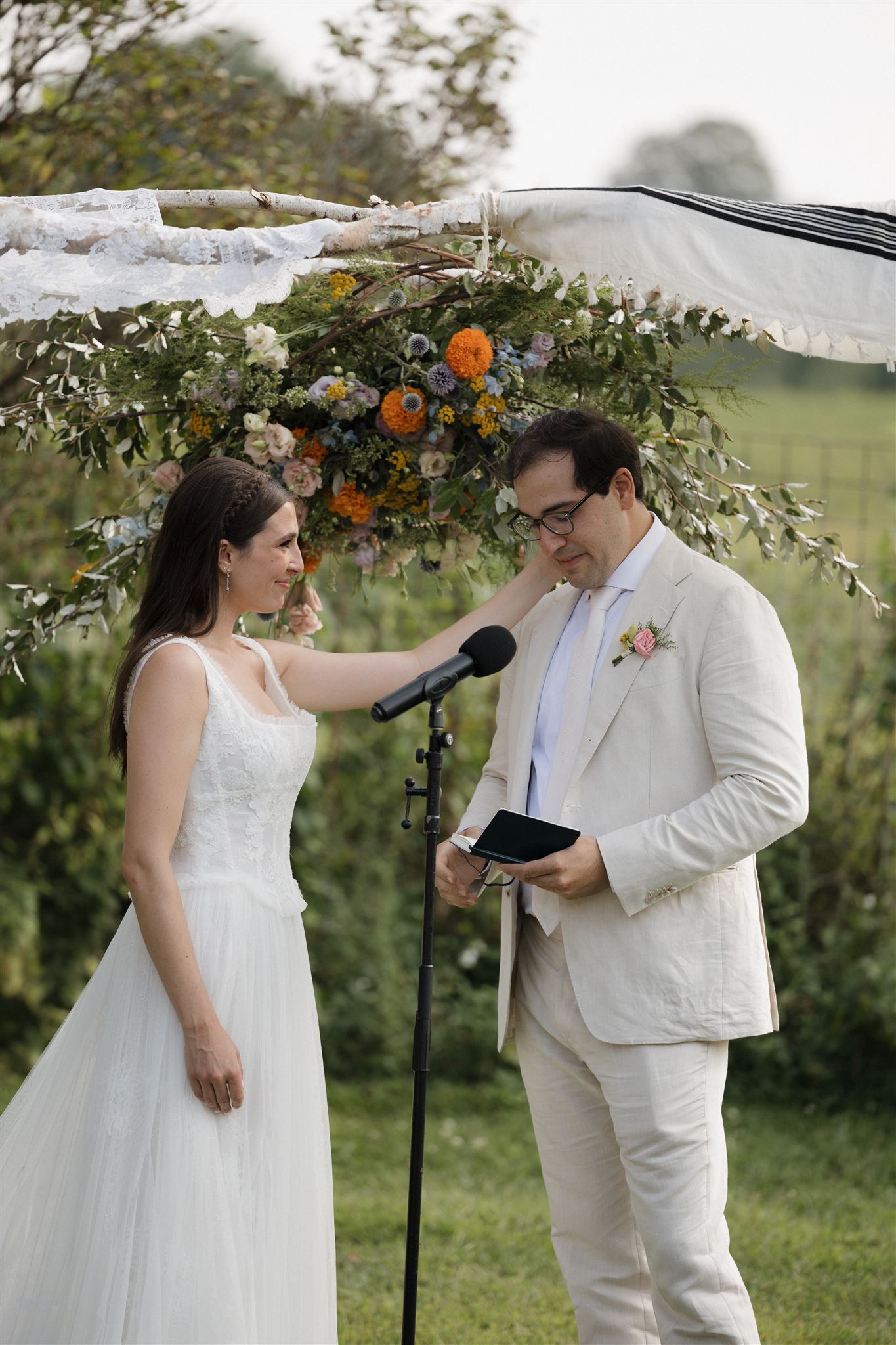 groom reads his vows as his bride holds his cheek