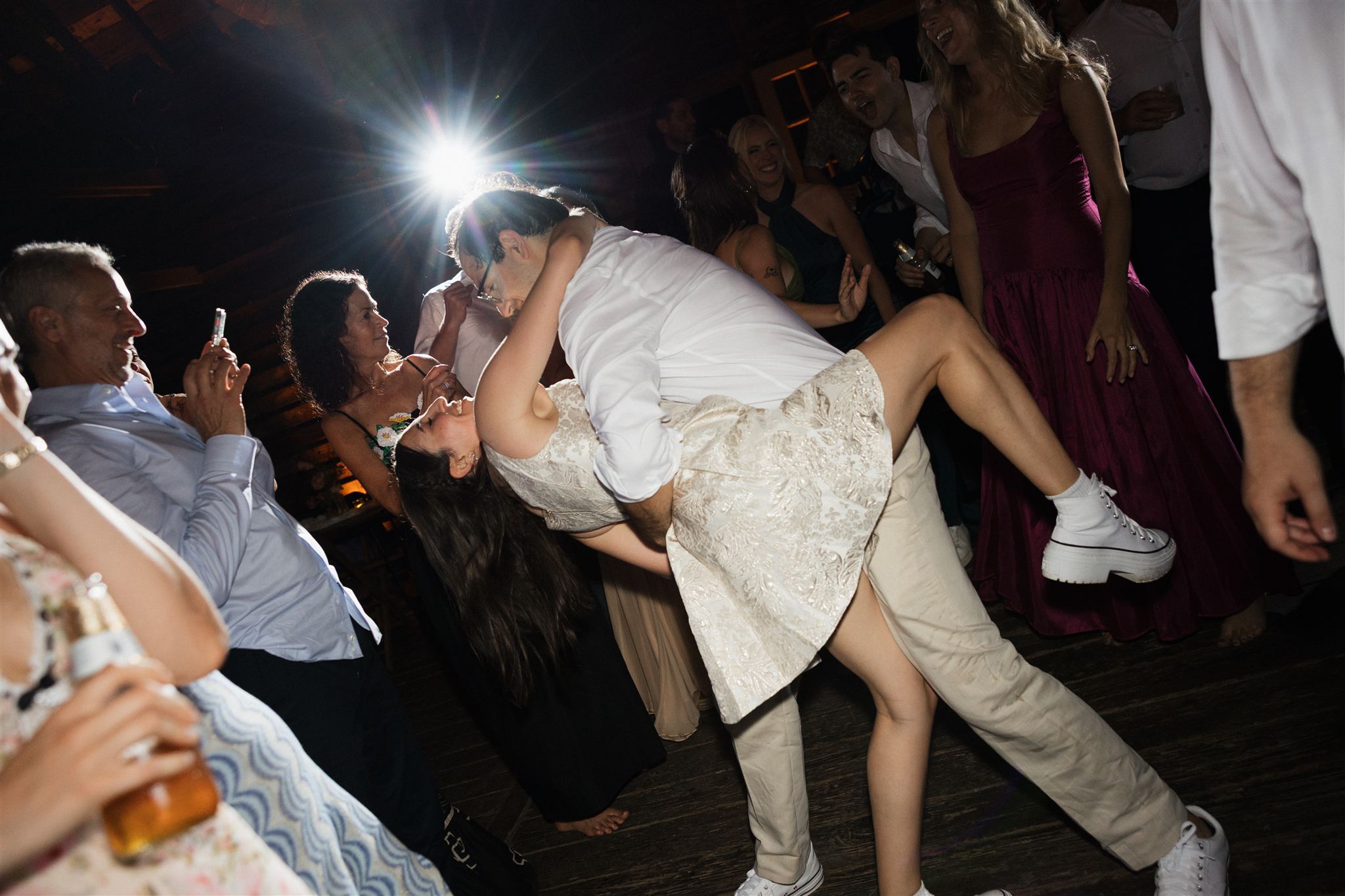 bride and groom share a dance as their guests look on