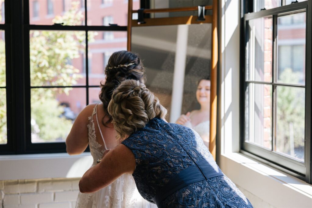 bride gets help finishing her prep from her mom