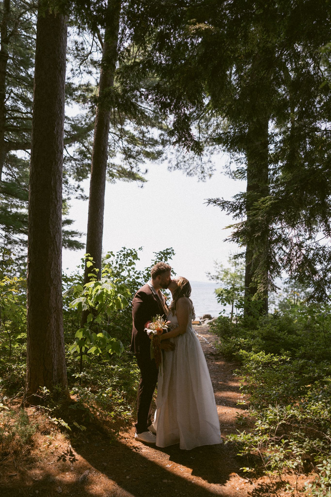 bride and groom share a moment  with the lake in the background at their sebago lake nh wedding venue