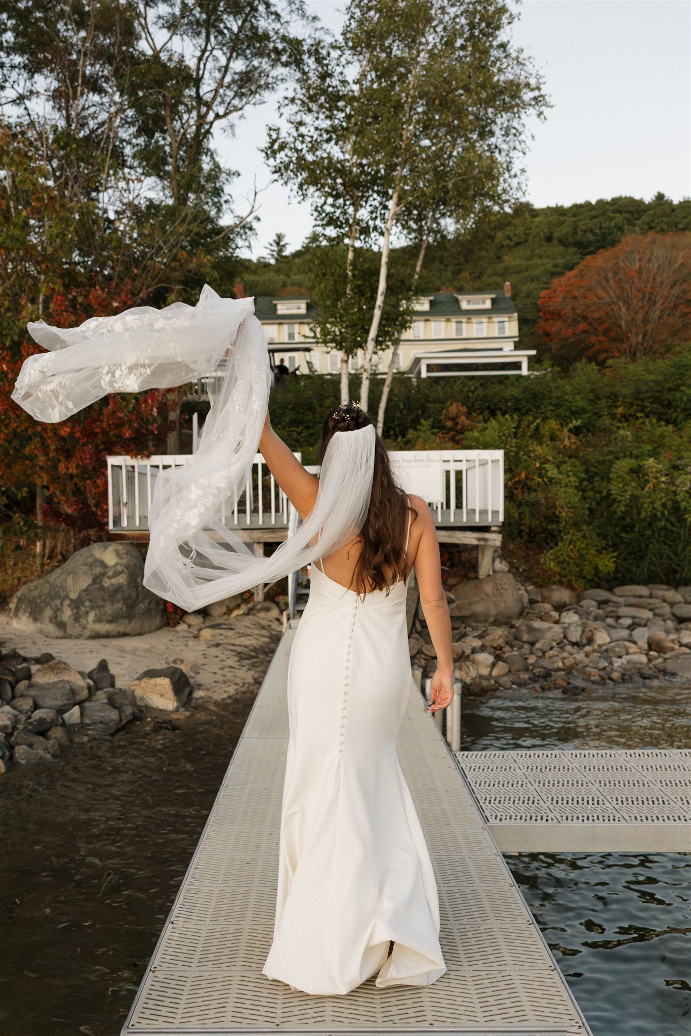 bride having fun on a dock at her lake venue in new hampshire