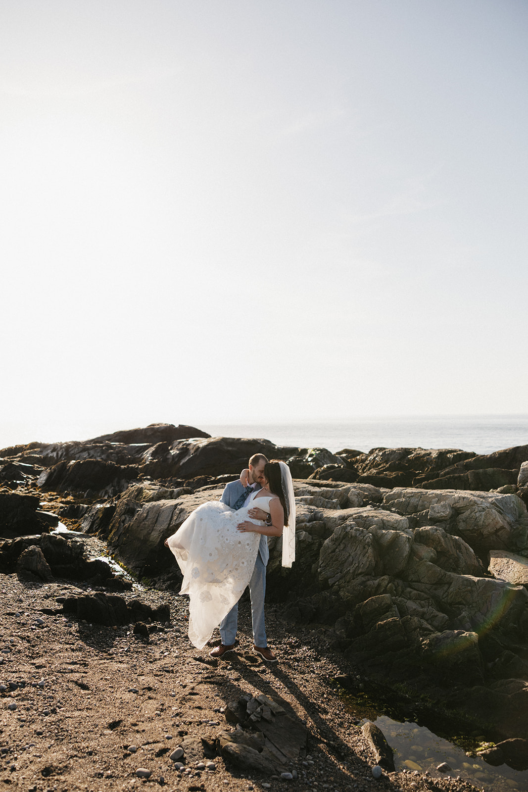 stunning couple pose on the beach together during after their Fuller Gardens elopement in New Hampshire