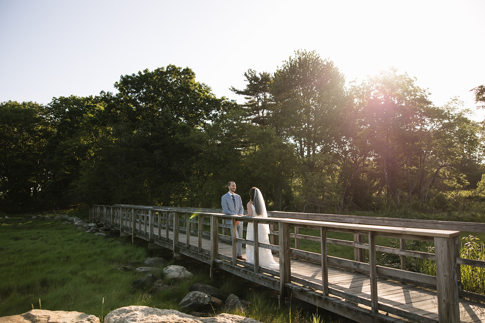 bride and groom talk on the boardwalk after their New Hampshire elopement