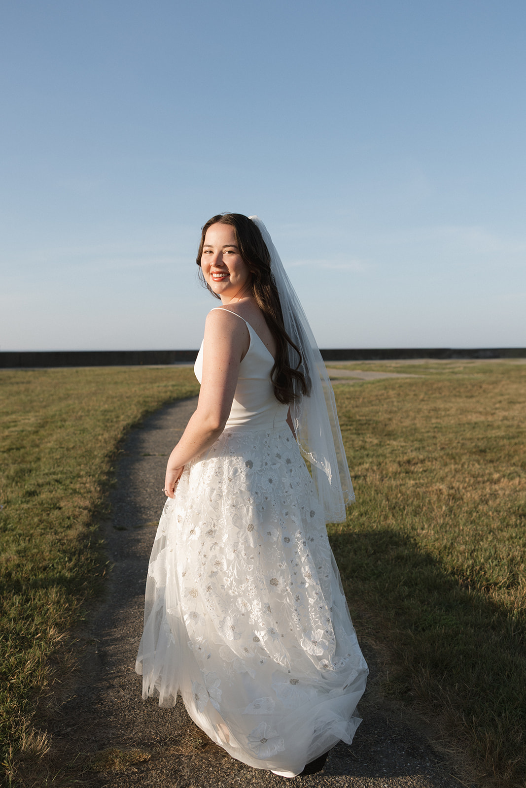 bride poses for a photo on the path