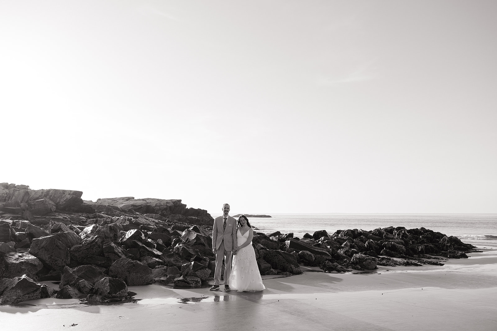 stunning couple pose on the beach together during after their Fuller Gardens elopement in New Hampshire