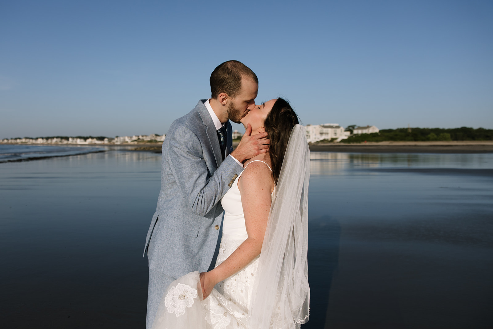 bride and groom share a kiss between the spotlights