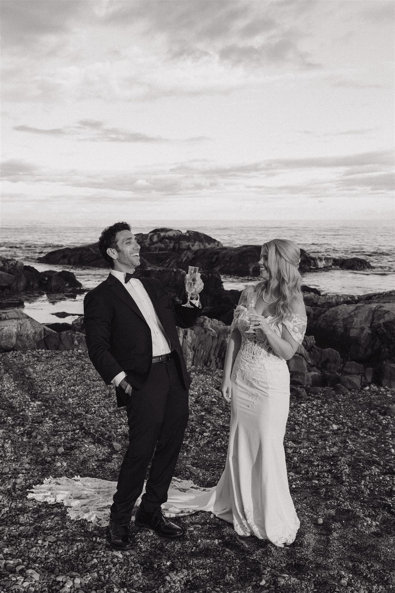 bride and groom share champagne on the New Hampshire coastline during their post wedding photoshoot