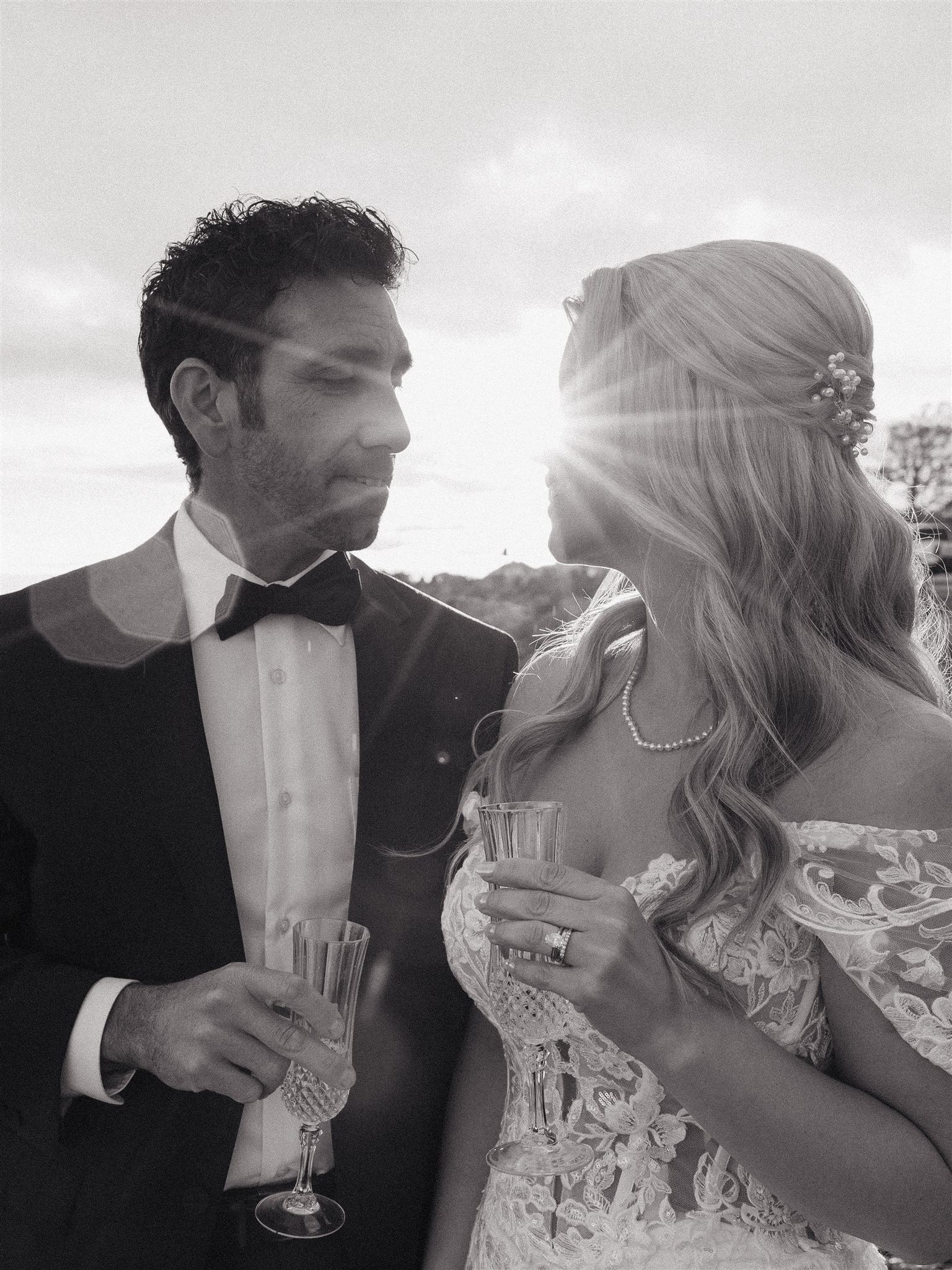 bride and groom share champagne on the New Hampshire coastline during their post wedding photoshoot