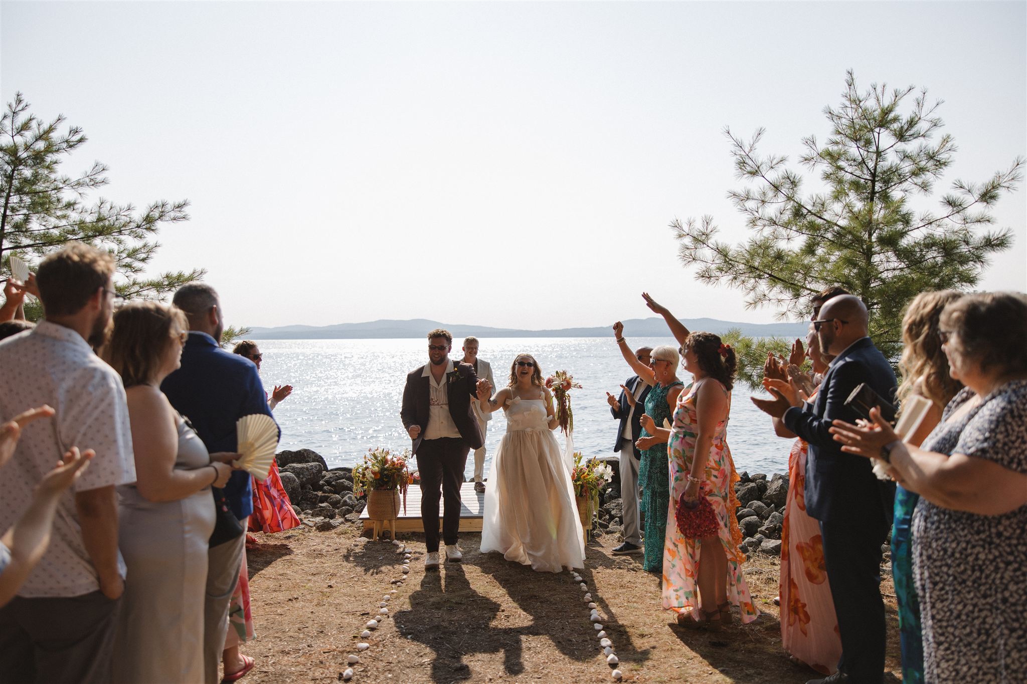 stunning couple walk away from their lakeside Maine wedding ceremony