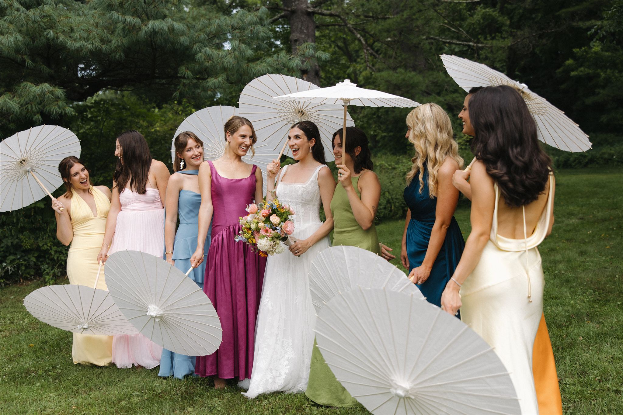 bridal party poses with umbrellas