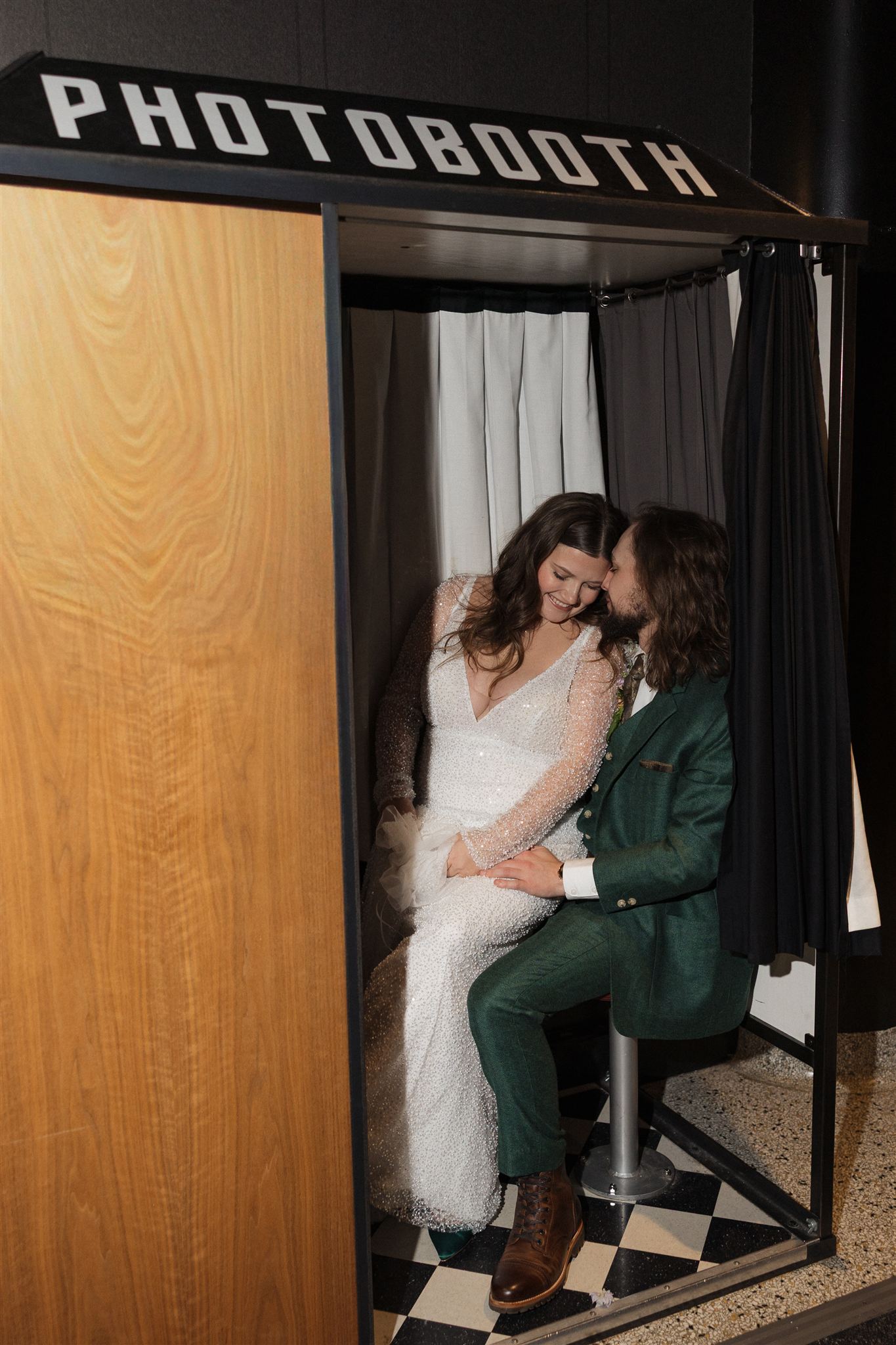 bride and groom laugh and share intimate moments in the photo booth 