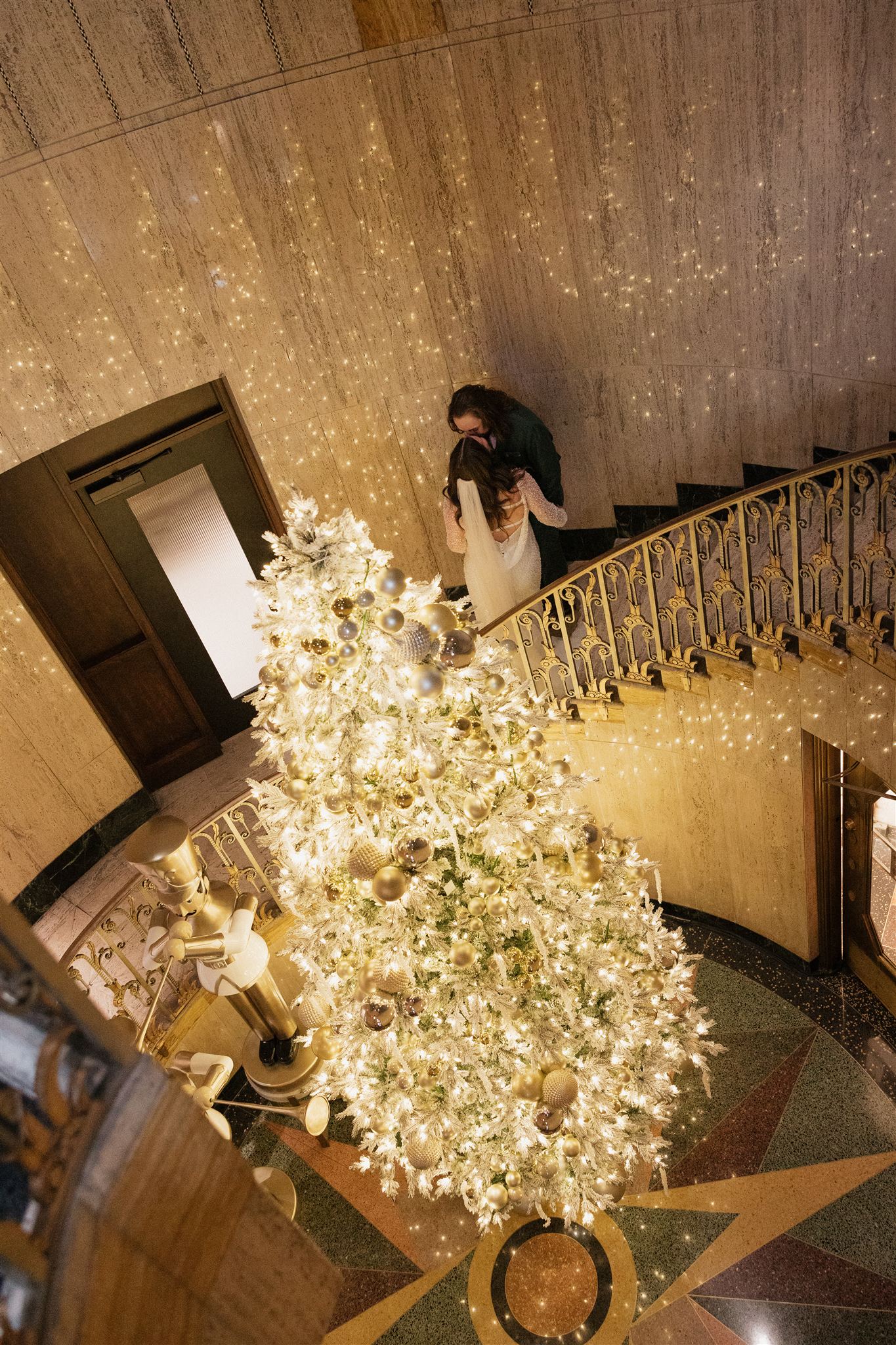 bride and groom walk together by the stunning Christmas tree, having your elopement around a holiday is a great way to make your elopement special