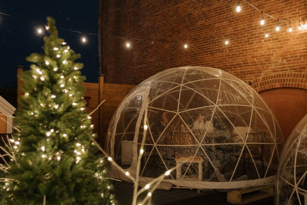 bride and groom eat a romantic dinner together in  rooftop igloo