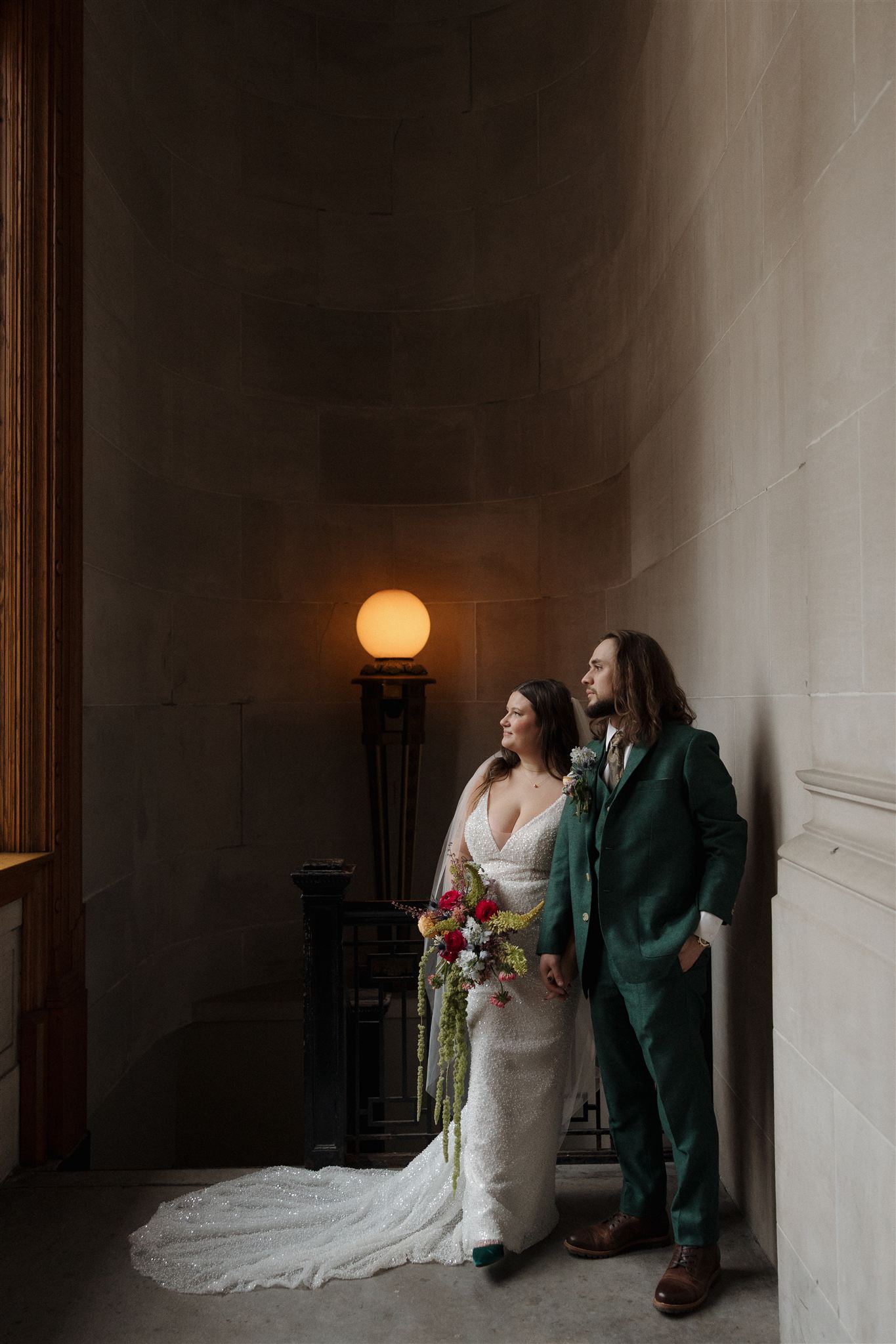 bride and groom pose together looking out the window of the Indiana state house