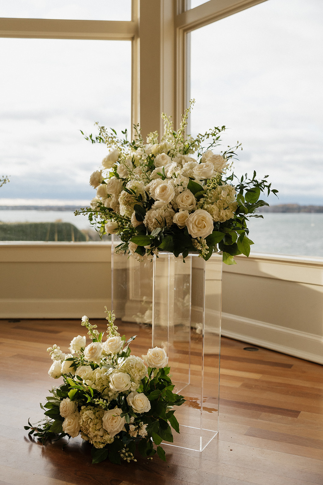 Ocean cliff wedding venue in Rhode Island sits ready with white florals sitting in the bay window 