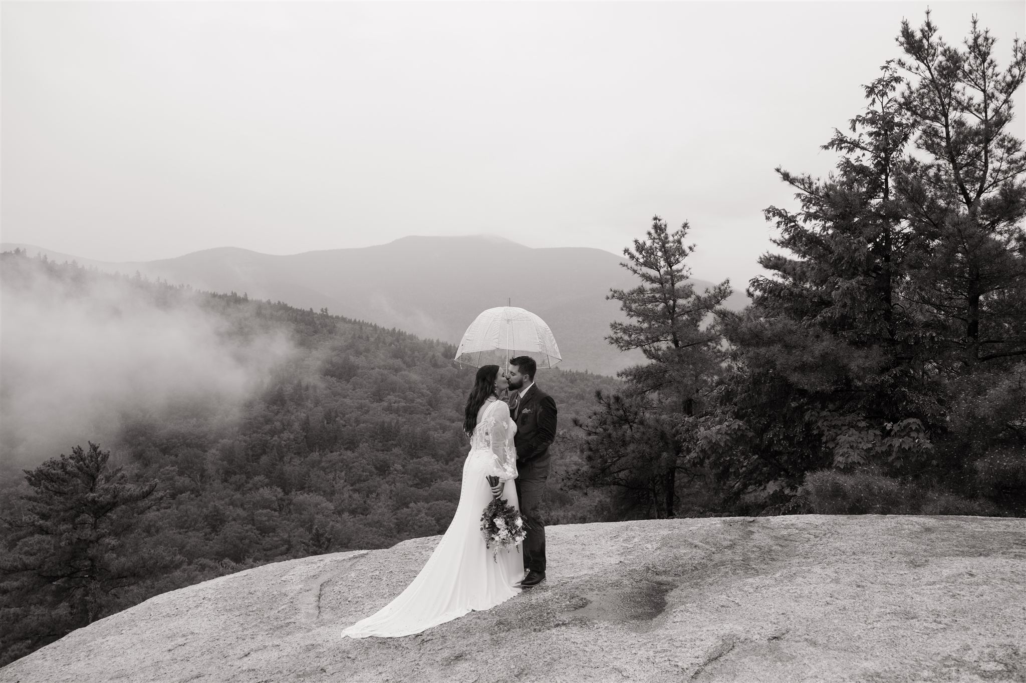 bride and groom share a kiss on the edge of Cathedral ledge
