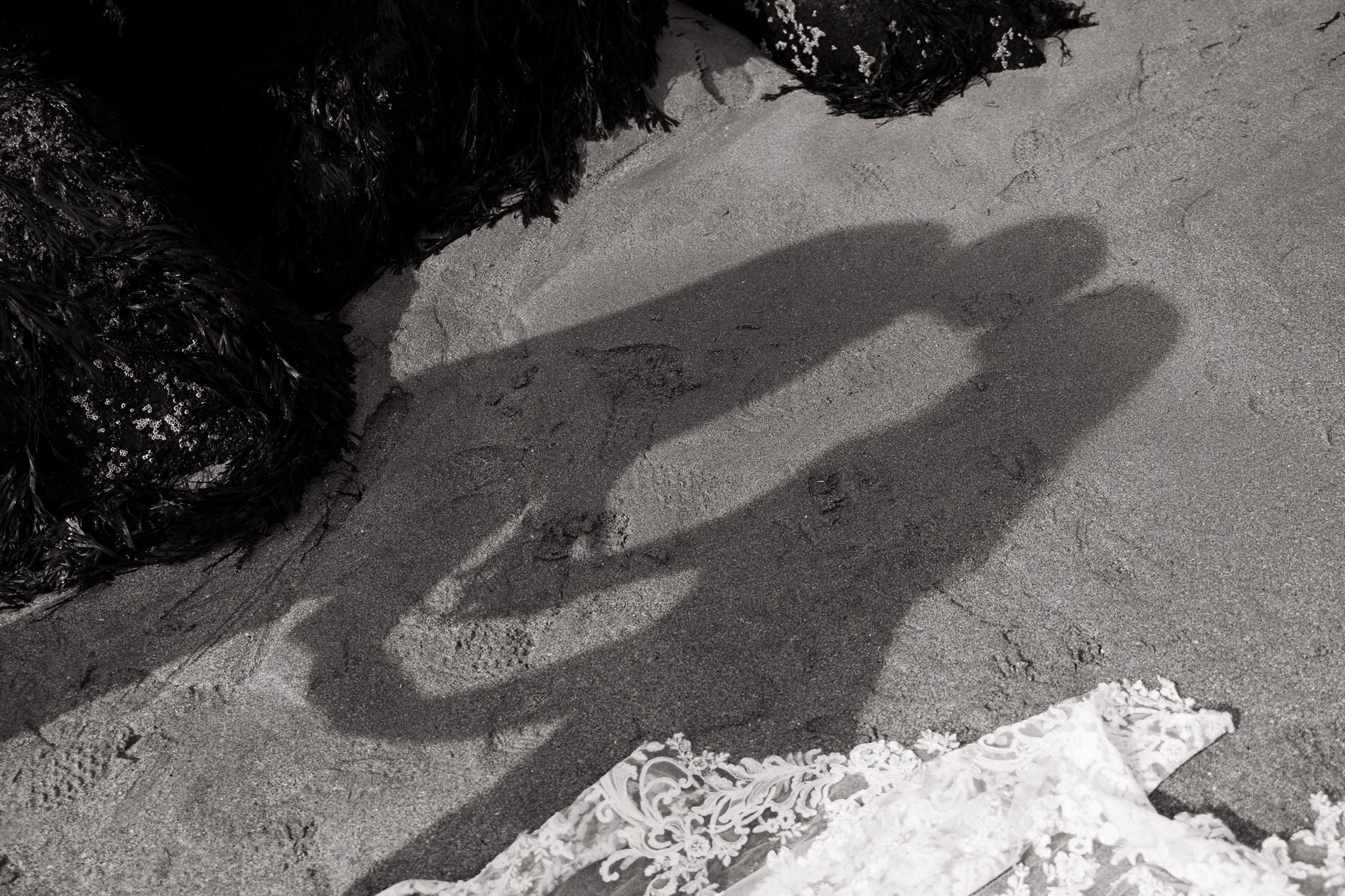couple share a kiss as Erica captures their shadows on the beach