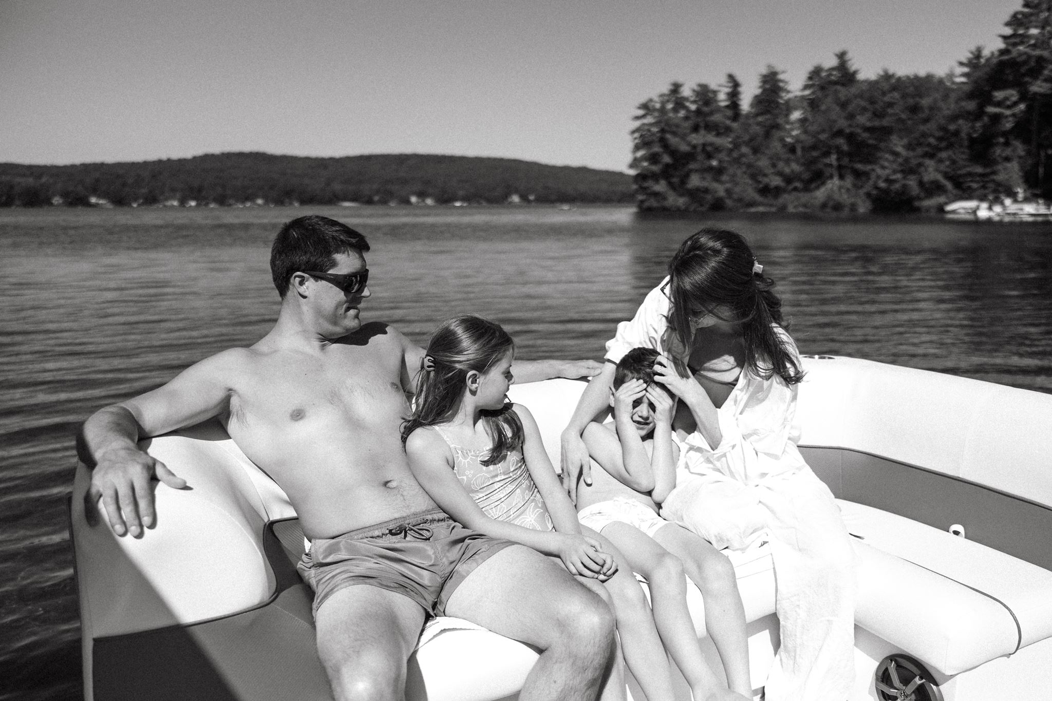 family hangs out on the pontoon as they celebrate together