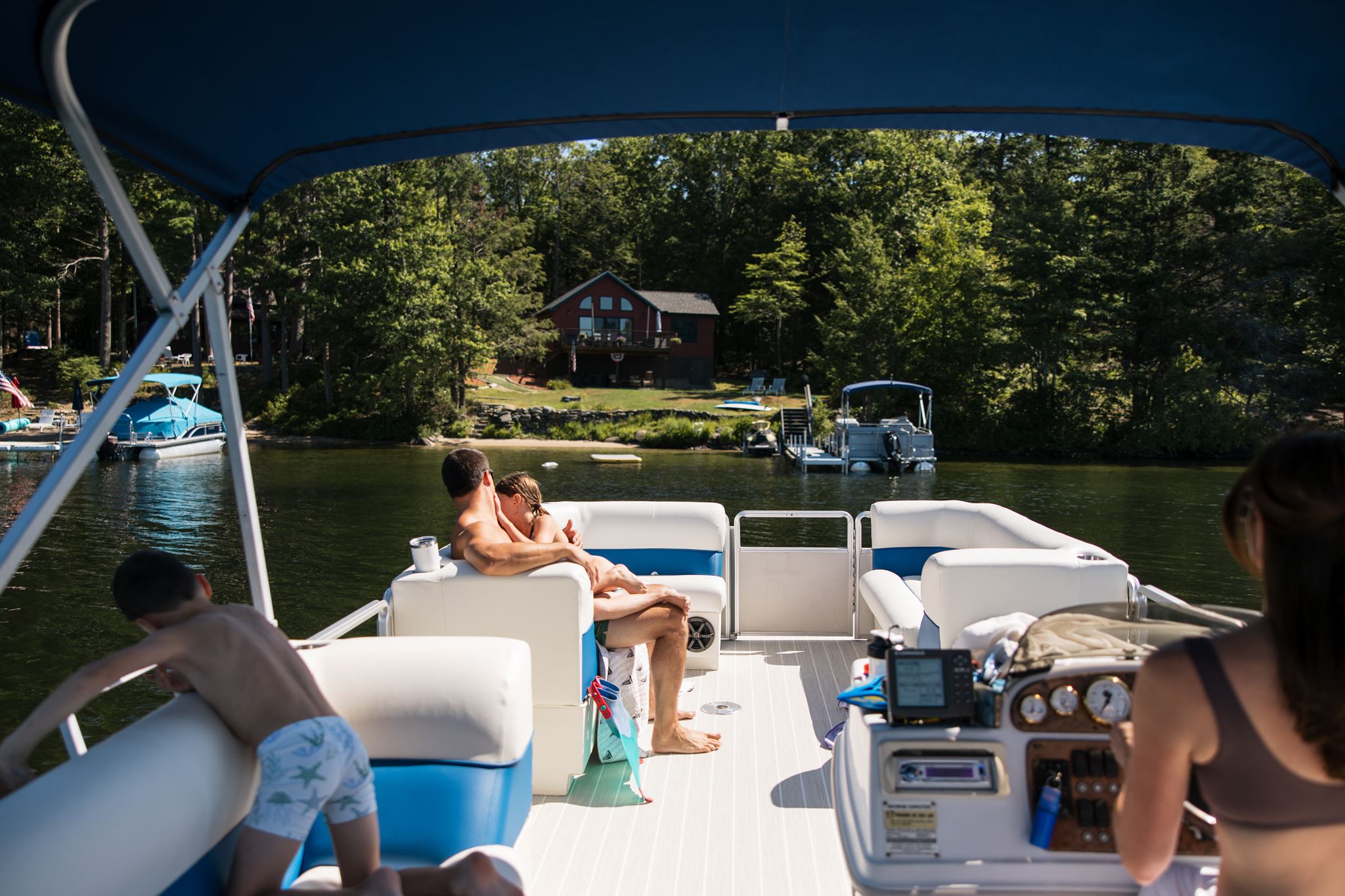 family hang out together on their pontoon boat during their unique documentary style family photos